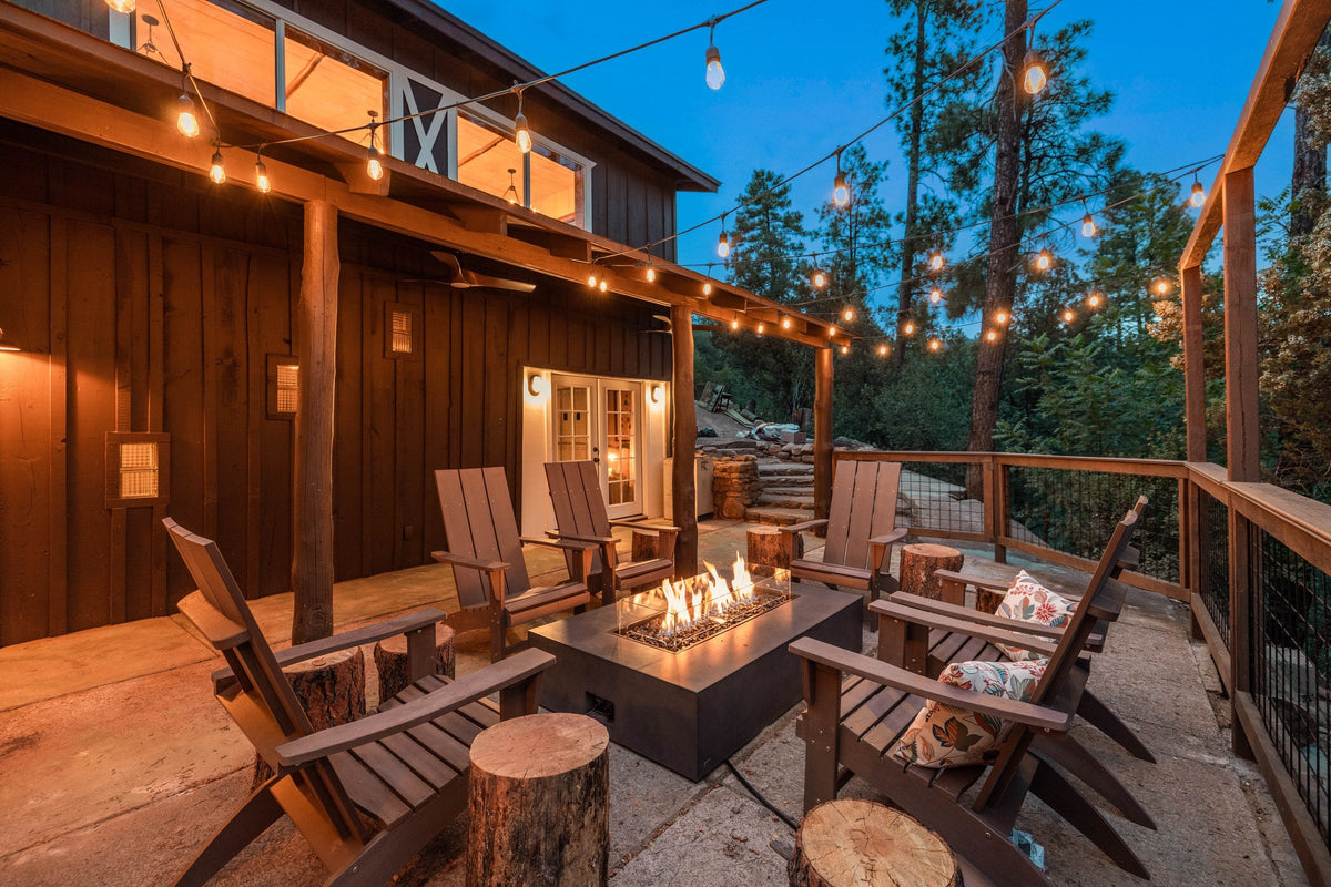 EcoSmart Fire Wharf 65 fire table on a cabin deck at dusk with string lighting