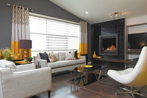 Kingsman Bentley zero clearance direct vent gas fireplace with ember glass media on the glass tray, set into a black tiled feature wall in a modern living room